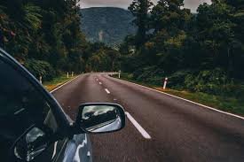 A man on a modern road trip ideas journey along Utah’s Scenic Byway 12 with a journal and portable stove by a red rock canyon.
