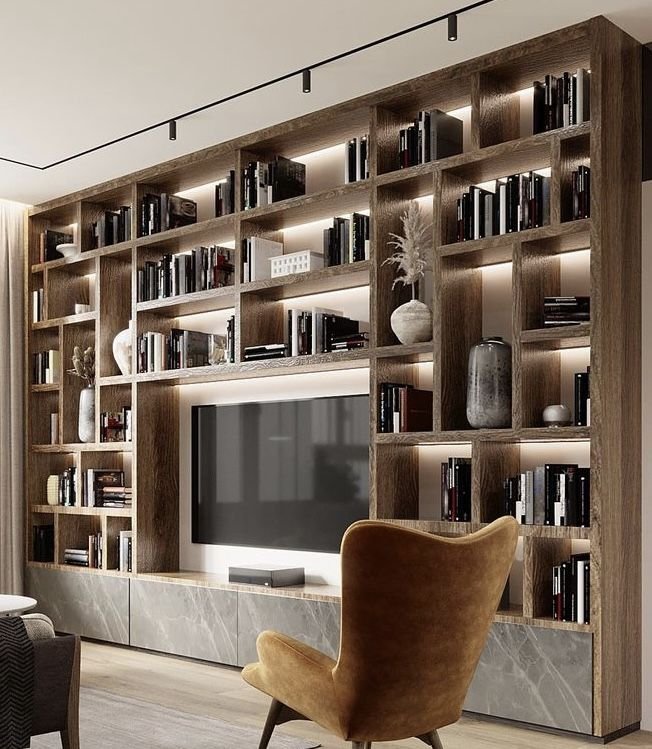 a leather recliner a wall mounted TV and a steel framed bookshelf