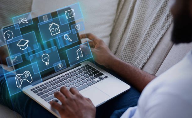 Image of a person using a laptop with holographic app icons floating above the screen, symbolizing productivity tools, alongside the title "15 Life-Changing Apps Every Remote Worker Needs to Boost Productivity in 2025."
