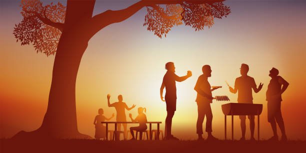 Men enjoying a fireside gathering at sunset, bonding over barbecue, conversation, and outdoor rituals