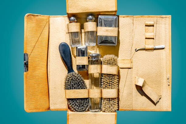 An open vintage tan leather men's grooming kit displaying classic essentials like glass bottles and brushes, representing a complete grooming arsenal.