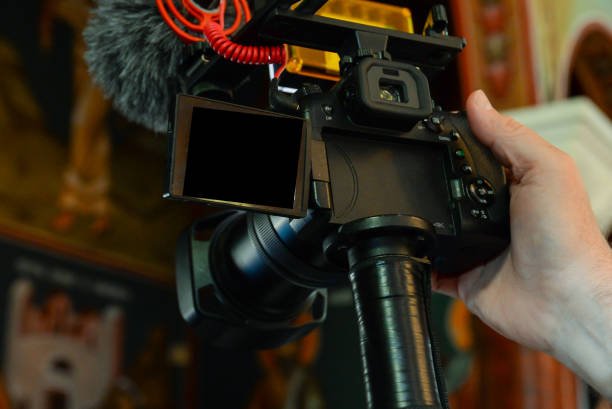 A content creator's mirrorless camera with a shotgun microphone and flip screen, mounted securely for on a camera mount for a professional filming setup.